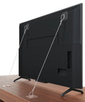 Back view of a flat screen TV secured by Six Pack Adjustable Forty Two Inch Metal TV Safety Straps No Drill Adhesive Anti Tip Wall Anchors.