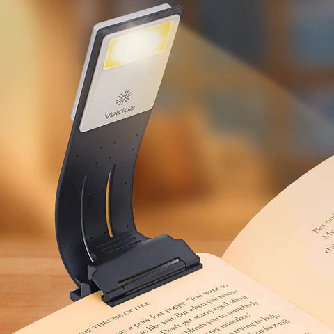 Clip On Bookmark Reading Light For Books In Bed With Adjustable Brightness Levels Soft Eye Friendly LED Built In USB Charge Ideal For Readers And Kids clipped onto an open book.