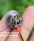 Close-up of a single brushless motor on a fingertip, showcasing the outer rotor dynamic balance treatment.