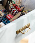 Champagne Bronze Cabinet Pulls With Escutcheon Backplates on a drawer in a kitchen setting
