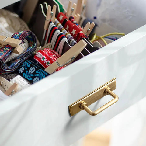 Champagne Bronze Cabinet Pulls With Escutcheon Backplates on a drawer in a kitchen setting