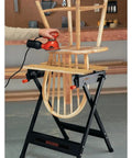 Pro-Grade Portable Workbench With 350-Pound Capacity in use, clamping a wooden chair for sanding in garage workspace