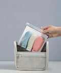 Hand holding Grab And Go Leak Proof Travel Bottle Set Of 3 60 Ml Refillable Squeezable Containers with Labels and Clear Carry Bag