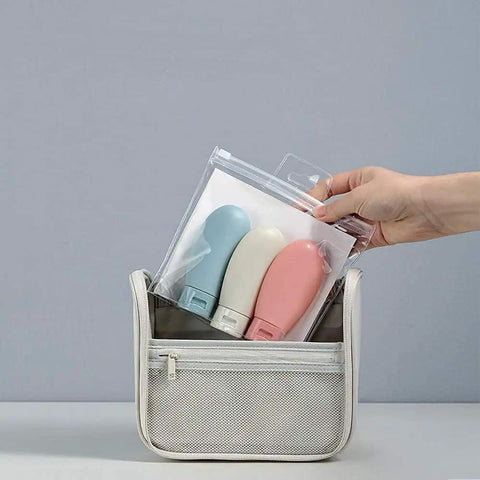 Hand holding Grab And Go Leak Proof Travel Bottle Set Of 3 60 Ml Refillable Squeezable Containers with Labels and Clear Carry Bag
