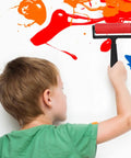 Child using the 3 Piece Manual Stamping Ink Roller Kit Featuring A Super Silky Smooth Cylinder And Rugged Red Plastic Handle on a wall.