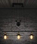 Drop Dead Modern Industrial Chandelier 3 Light Retractable Pulley Pendant with exposed bulbs over dark brick wall.