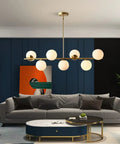 Groovy Mid Century Modern Pendant Light Set Featuring Sleek Glass Globes and Gold Finish above a modern living room sofa.