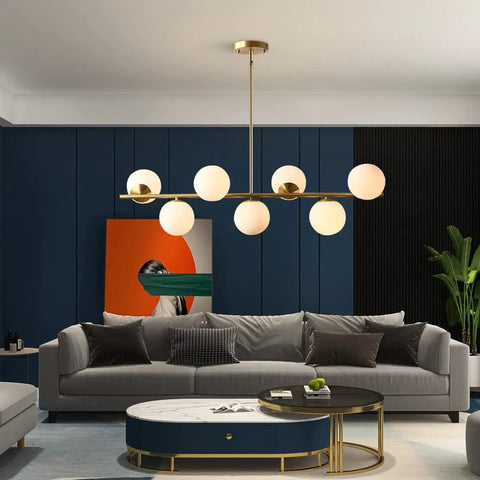 Groovy Mid Century Modern Pendant Light Set Featuring Sleek Glass Globes and Gold Finish above a modern living room sofa.