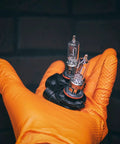 Orange nitrile glove holding two clear halogen headlight bulbs with orange bases