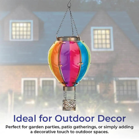 Colorful solar hot air balloon lantern with flickering flame effect hanging outdoors against house background