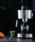 Compact Semi Automatic Coffee Maker Featuring 5 Bar Pressure Pump For Creamy Lattes And Bold Espressos Silver Steam Frother on countertop with coffee cup and croissant.