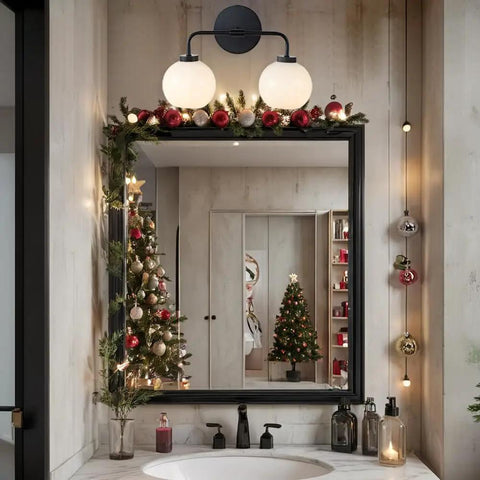 Double Glass Globe Wall Sconce, 17 Inch Sleek Modern Design In Matte Black over decorated vanity mirror with holiday decor.