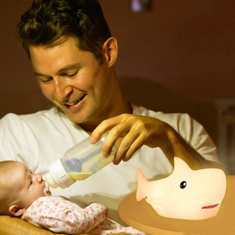 Father feeding baby by lamp light of Rechargeable Cute Squishy Shark Night Light For Kids And Teens Soft Silicone Touch Lamp With Gentle Glow Safe Nursery Nightlight Decor Gift For Boys And Girls