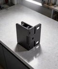 Boss Level Stainless Steel Hydraulic Glass Door Hinge Offering No Hassle U Shape Clip Installation And Smooth Operator Soft Close Action For Frameless Doors In Sleek Black, positioned on a countertop.