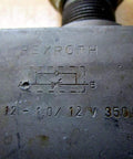 Rexroth Bosch DRV12-1.0/12V Flow Control Valve with etched labeling, showing hydraulic flow diagram and specifications.