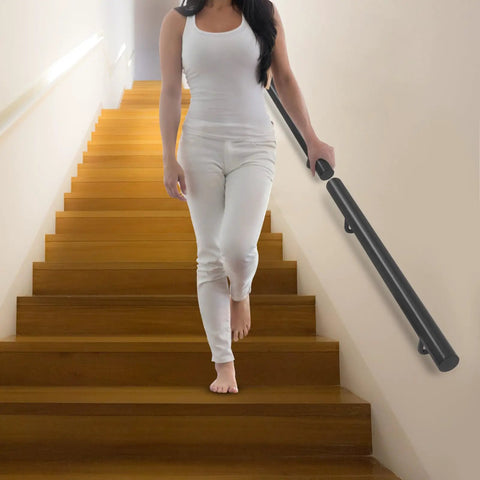 Rock Solid Wall Mounted Stair Handrail Crafted From Premium Black Stainless Steel, shown on indoor steps with user.