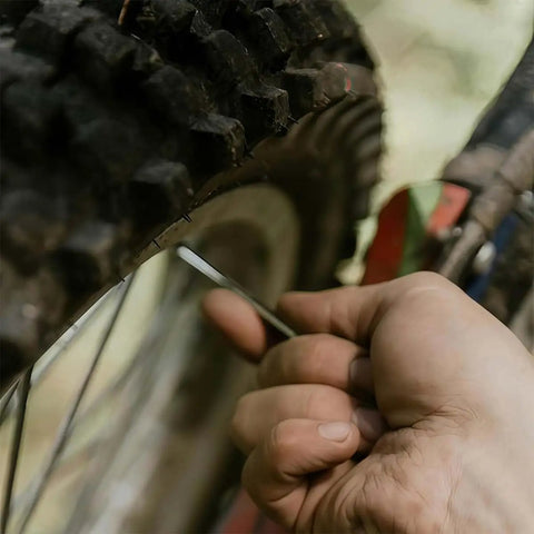 Using 8-Piece Ball Head Hex Key Set With L-Shaped Allen Wrenches on bike tire, red holder visible, for bike fixes, metric sizes.