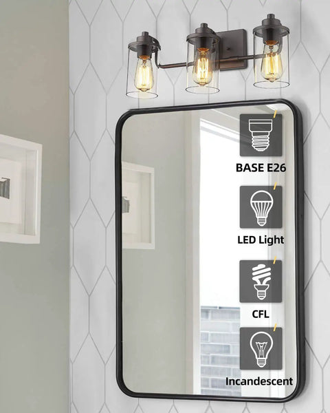 Three Light Farmhouse Vanity Light Fixture in oil rubbed bronze above mirror showing light bulb options, clear glass shades.