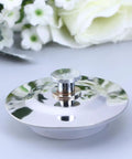 Drain Stopper Flat Cover 40-45mm Stainless Steel for Bathtub resting beside white flowers on a light surface.