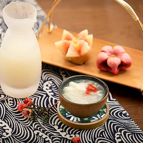 Ceramic bowl on bamboo mosaic coaster next to drink pitcher and fruit with Three Styles DIY Mosaic Coaster Kit No Glue Needed.