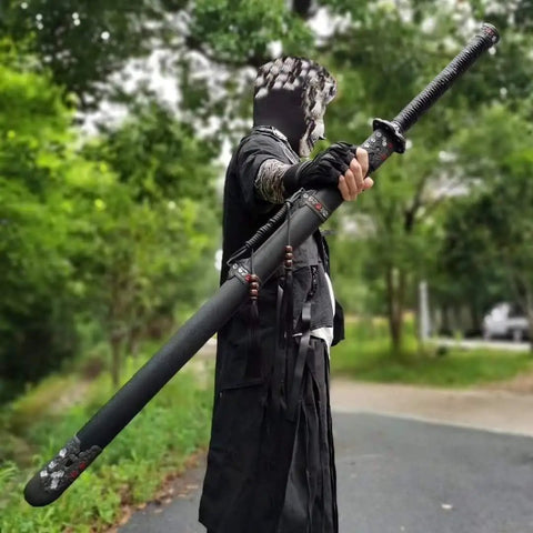 Person holding Hand Forged Longquan Style Dao Sword With High Carbon Steel Blade Full Tang and matte black scabbard outdoors