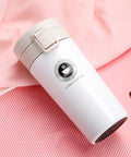 Dope 380 Ml Double Wall Stainless Steel Coffee Mug With Solid Lock Leak Proof Push Button Lid and Built In Mesh Filter on pink background.