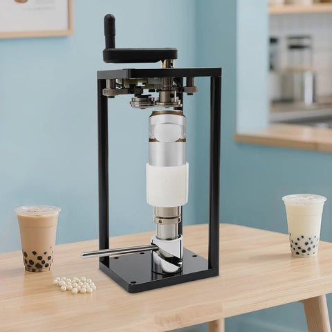 Top Shelf Manual Jar Sealer For 55Mm Soda Pots With Heavy Steel Build and Smooth Rotary Winder on a wooden table with drinks.