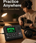 Pocket Sized All In One Portable Digital Metronome Tuner With Tone Generator for guitar practice on desk next to musician.