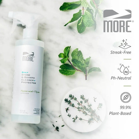 All In One Stone And Quartz Cleaner And Protector Spray For Granite Marble And Quartz Surfaces On Kitchen And Bath Counters And Floors Water Based Neutral PH Formula With Peppermint Thyme Essential Oil 16 Oz bottle on marble surface with herbs