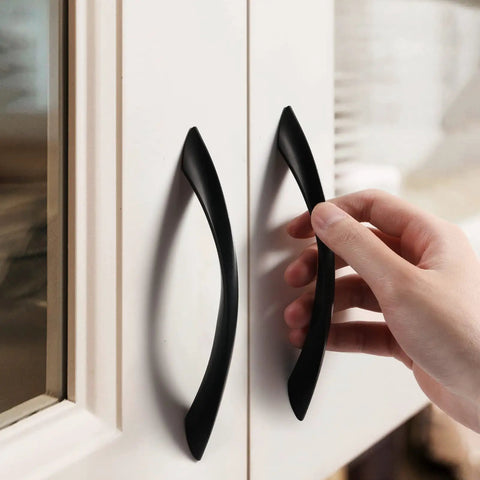 Person installing 5 Inch Arch Twisted Matte Black Cabinet Pulls For Kitchen Drawers And Cabinets, Heavy Duty Zinc Alloy Hardware