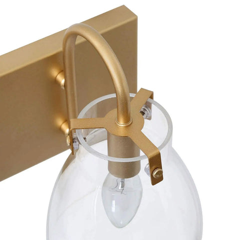 Close-up of a 3 Light Modern Vanity Light Fixture in Brass Finish With Clear Glass Shades For Bathroom, showing bulb detail