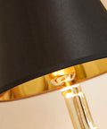 Close-up of Gold Gun Desk Light With Linen Shade, showing gold metal body and black shade detail, Nordic Metal Craft design.