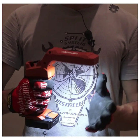 Person holding cordless LED flexible head work light with 500 lumens, illustrating portability and compact design for workshops and DIY projects.