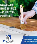 Person using 96 Pack 1.5 Inch Chip Paint Brushes For Painting And Staining, Solid Wood Handles on wooden deck.