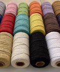 Spools of macrame cord 1.5mm cotton string rope for DIY crafts 109 yards with 35 color options arranged in rows on a table