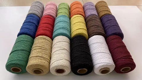 Spools of macrame cord 1.5mm cotton string rope for DIY crafts 109 yards with 35 color options arranged in rows on a table