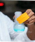 100 Pack Latex Protective Finger Sleeves Shield Your Digits From Daily Wear While Delivering Sick Grip And Breathable Comfort For Heavy Gaming Or Daily Grind Tasks, orange sleeves holding a lab beaker.