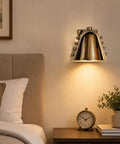 Modern Adjustable Chrome Wall Sconce Polished Metal E26 above a nightstand in a stylish bedroom setting.