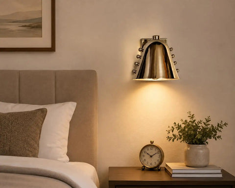 Modern Adjustable Chrome Wall Sconce Polished Metal E26 above a nightstand in a stylish bedroom setting.