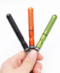 Hand holding three colored rods from Six Pack Ferro Rod Fire Starter Kit With Striker Flint And Steel Fire Sticks Magnesium Rod