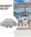 Beefy Stainless Steel Sailing Pulley Block Set 4 Pack For Marine Rigging And Kayak Gear with a sailboat in the background