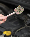 Holding a tool from the Auto AC Compressor Repair Tool Set 3 Piece Disassembly Kit for compressor removal under the hood.