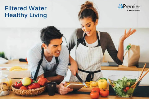 Couple preparing vegetables in kitchen, promoting Whole House Water Filtration Kit With Built In Bypass Valve for healthy living.