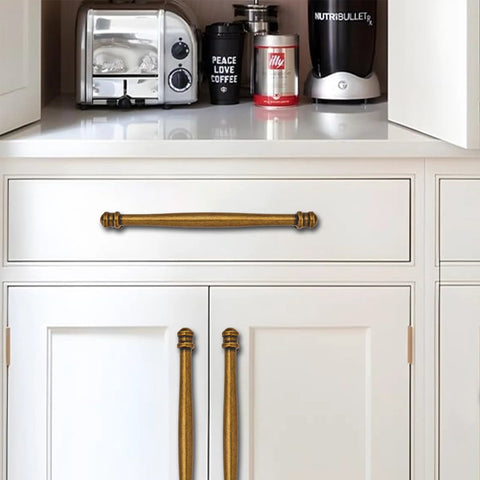 2 Pack 3-1/2 Inch Center to Center Antique Brass Cabinet Pulls on white kitchen cabinets, heavy-duty aluminum or stainless steel.