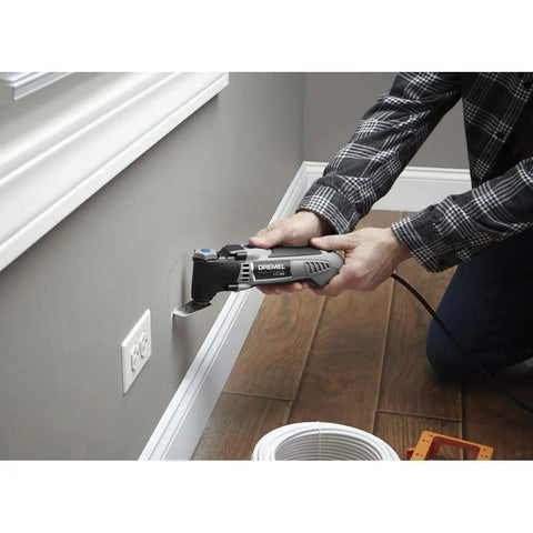 Person using Pro Grade Corded Oscillating Multi Tool Kit 120V 3.5 Amp Power, Reconditioned for precise wall cutting.