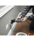 User operating a Reconditioned Corded Oscillating Multi Tool Kit Featuring Durable Metal Frame for precise wall cutting.