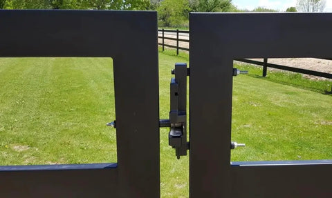 Two Way Gate Latch System Kit Black Finish Built Tough With Stainless Latch Pin Plate Helps Stop Gate Lean Corrosion Free Weatherproof Farm Fence Hardware For Barns And Fences So You Can Open It From Either Side, installed on black aluminum gate in grassy field.