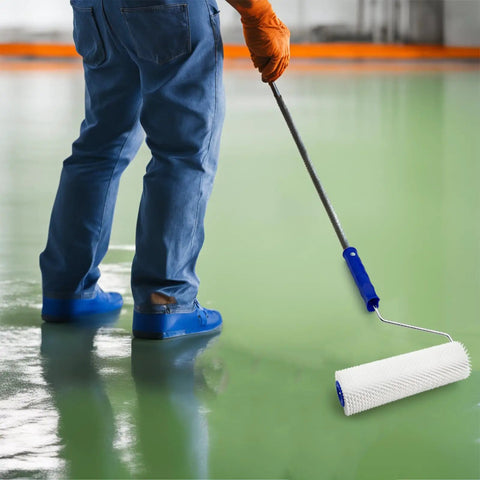 Worker using 9 Inch Spiked Roller For Self Leveling Screeds And Epoxy Floors Pro Grade Bubble Removal Tool on green floor