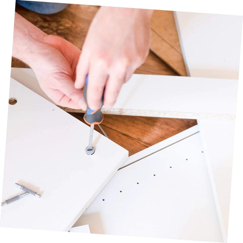 Person assembling furniture using screwdriver on white wooden panels