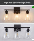 Three Light Black Vanity Lights Over Mirror, On Trend Modern Farmhouse Industrial Bathroom Fixtures With Metal Base And Clear Glass Shades, Wall Sconce Lighting For Bathrooms, Bulbs Not Included, showing illuminated and unlit versions.